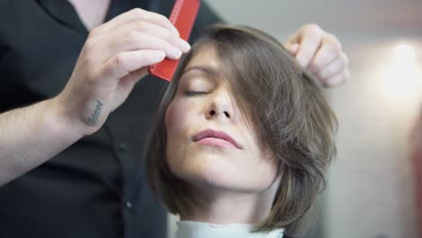Professioneller-Friseur,-Stylist,-Der-Die-Haare-Einer-Kundin-Kämmt-Und-Eine-Haarspange-Zum-Fixieren-Der-Frisur-Im-Professionellen-Friseursalon-Verwendet.-Schönheits--Und-Haarpflegekonzept