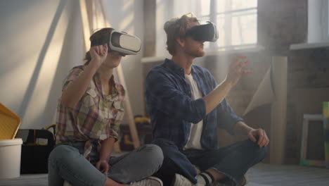 Focused-couple-using-headsets-indoors.-Family-sitting-among-construction-tools.