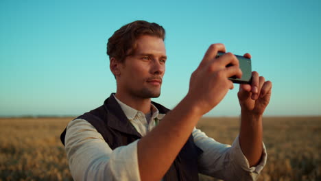 Hombre-Tomando-Fotografías-De-Campo-Con-Un-Teléfono-Inteligente.-Retrato-De-Trabajador-Agrícola-Enfocado.