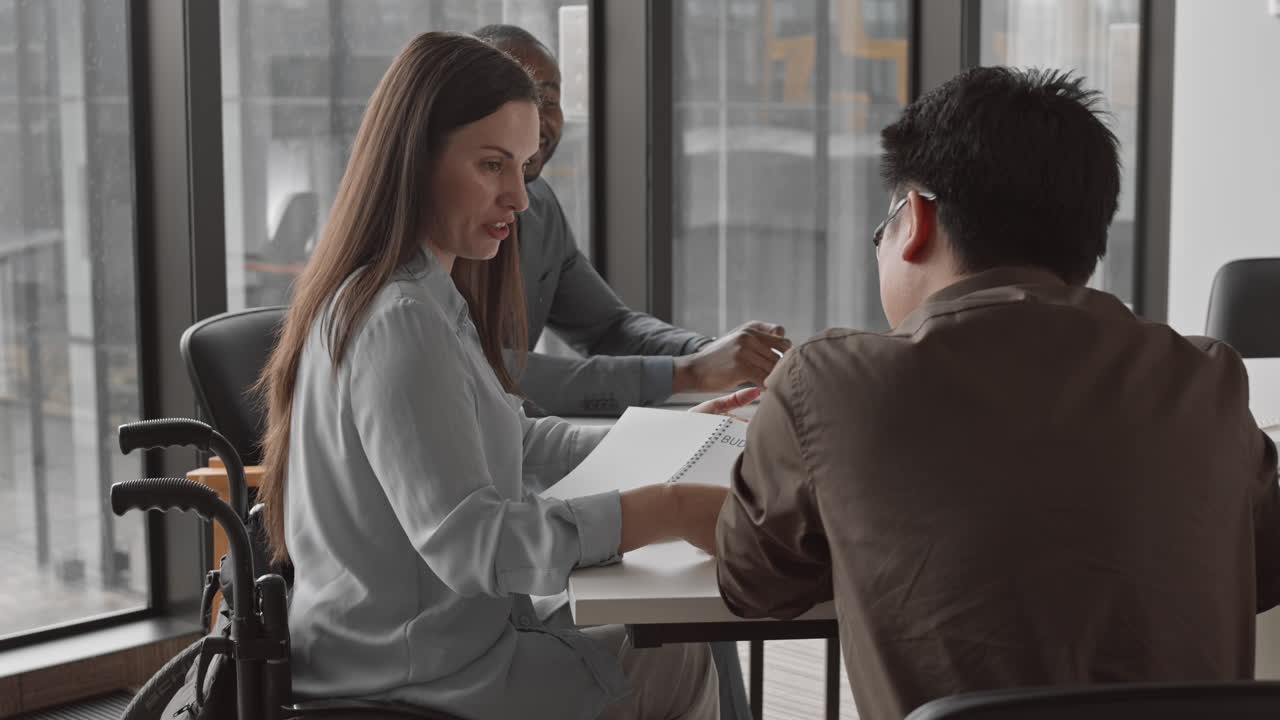 Female CEO with Disability Discussing Budget with Employees