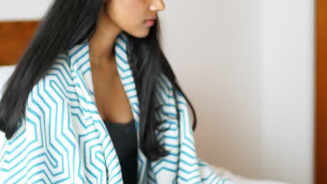 Woman-using-mobile-phone-in-bedroom