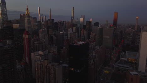 Evening-aerial-footage-of-high-rise-apartment-or-office-buildings-in-city.-Skyscrapers-at-dusk.-Manhattan,-New-York-City,-USA