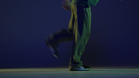 energetic young man, hip-hop dancer dancing, running away isolated over dark blue background in neon light. modern dance art, fashion, youth, ad, style. 4k, video