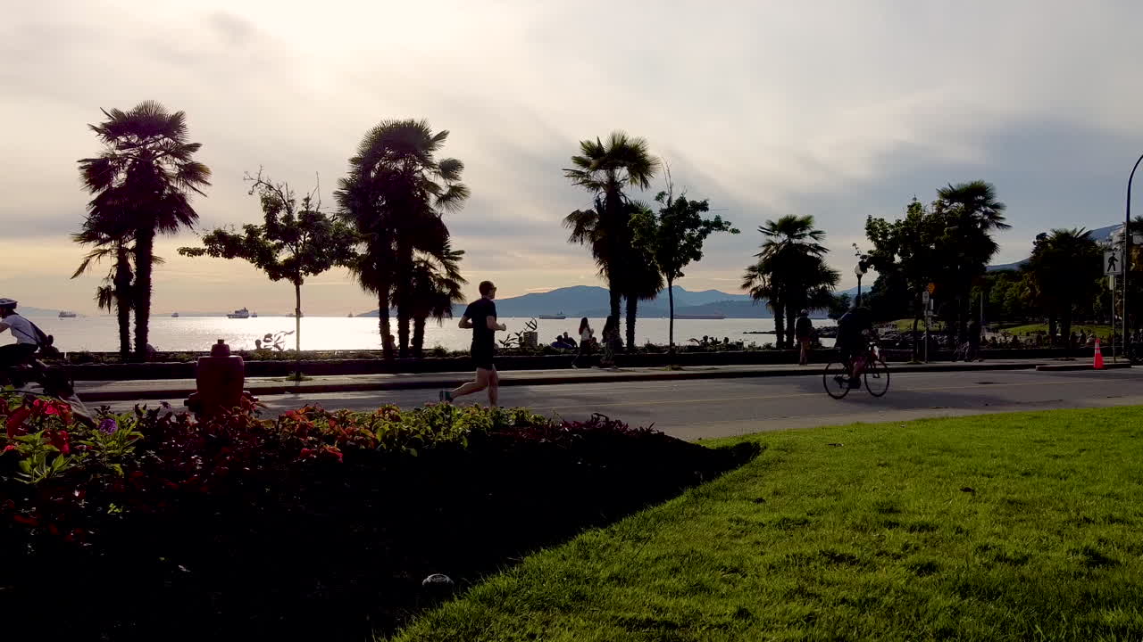 tropical beachside bike cyclist  skate boarders ebikes, unicycles fitness lanes dedicated to non gas powered vehicles by the beach on a beautiful sunset at English Bay Canada 2-3