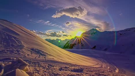 hyperlapse shot of beautiful sunset hiding between snowy mountains in ski area during winter - empty slope in the evening