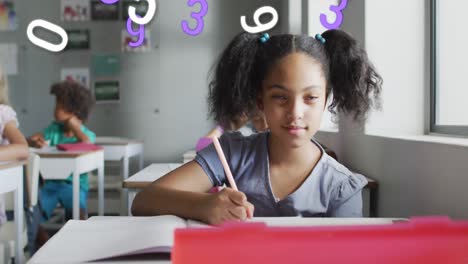 animación de números sobre una feliz estudiante biracial escribiendo en el escritorio en clase