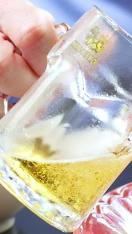 primer plano de la cerveza que se vierte en el vaso en la mesa de comedor