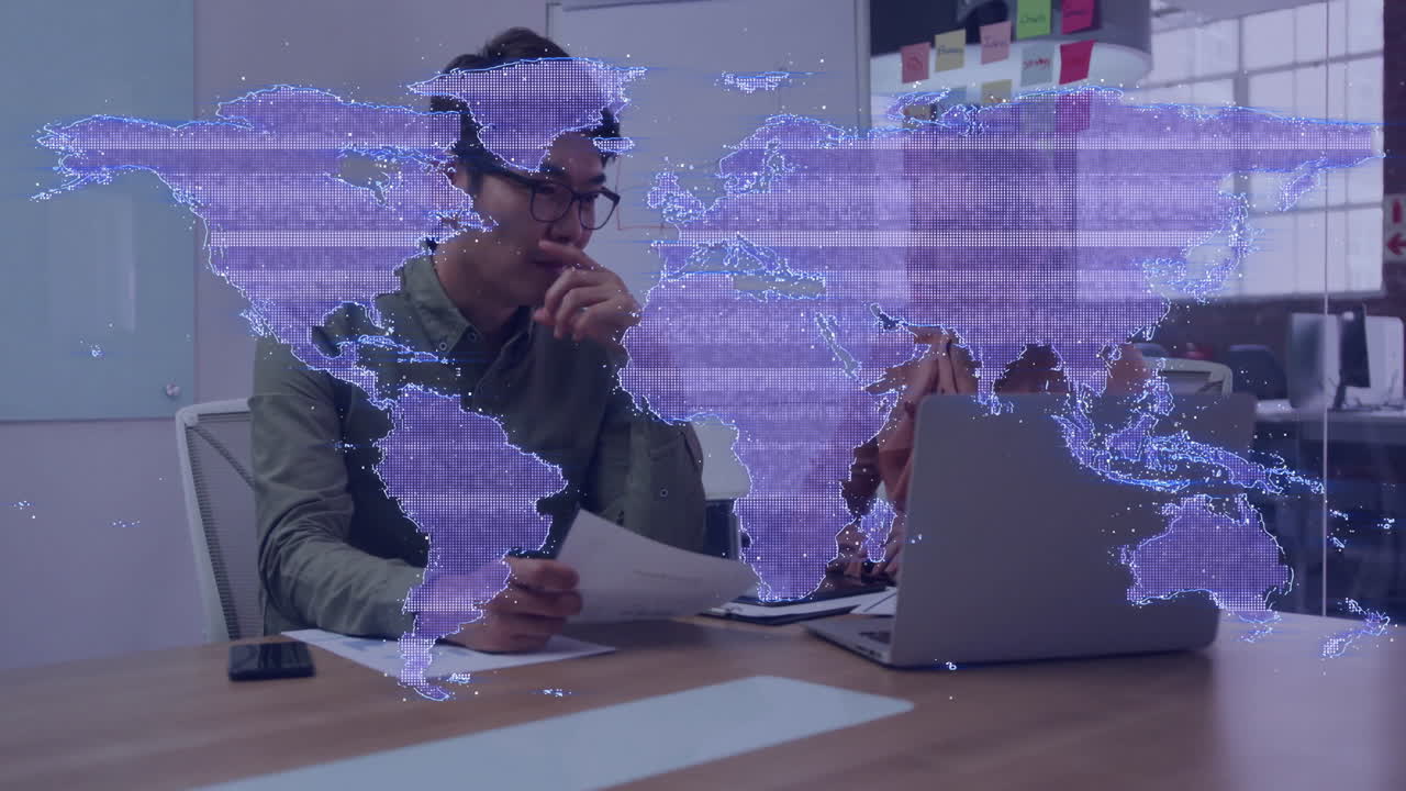 World map animation over thoughtful person working with laptop and documents