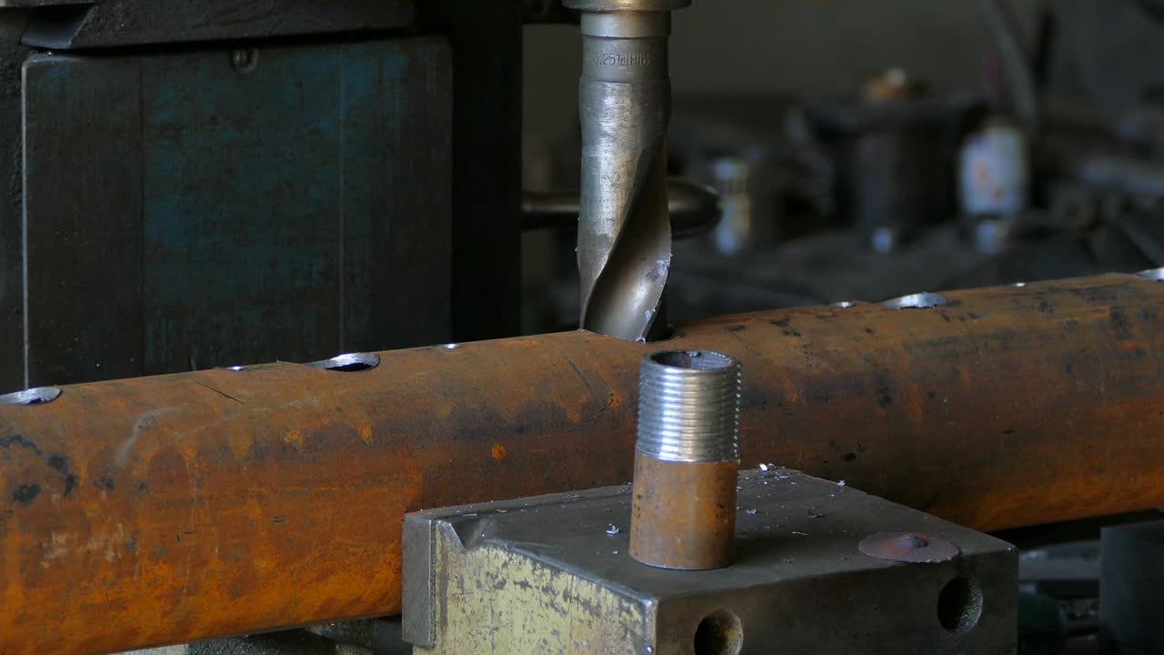 Worker Enlarging Hole In Tube With Drill