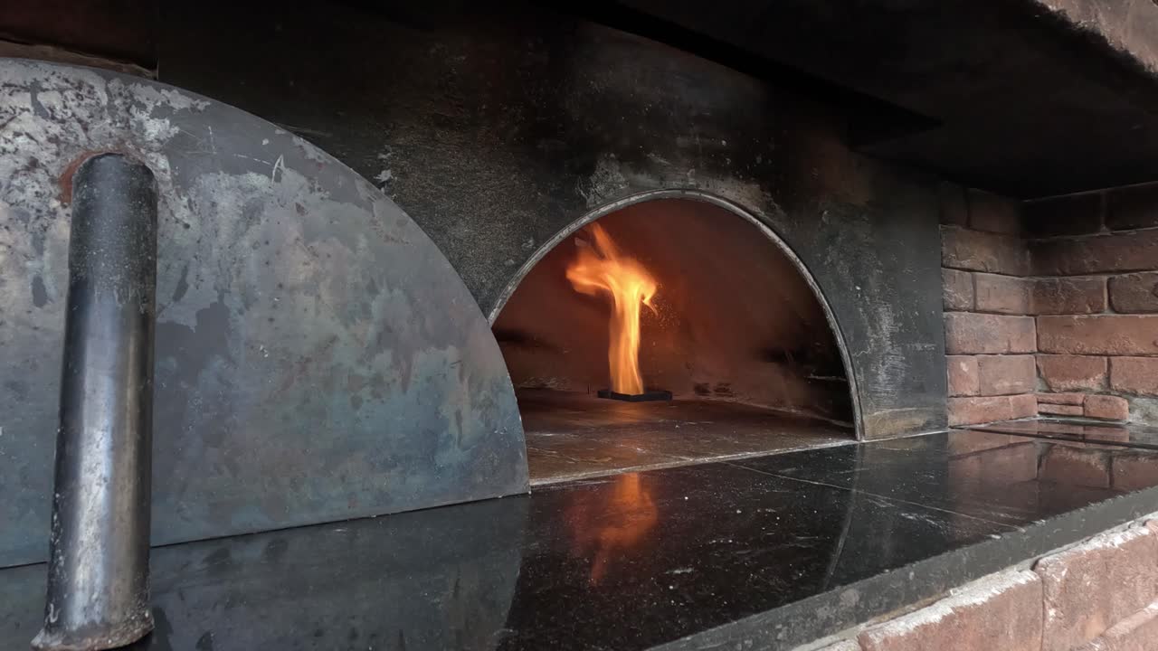 Geleneksel bir pizza fırınının içinde alevler parıldıyor.