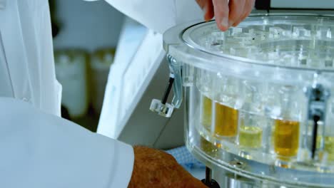 male scientist removing medical vials from centrifuge 4k