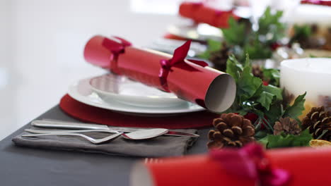 Close-Up,-Toma-De-Mano-Que-Muestra-Los-Cubiertos-En-Una-Mesa-De-Comedor-Navideña-Decorada,-Con-Galletas-Navideñas-Rojas-Dispuestas-En-Placas