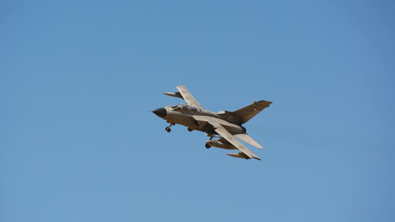 Combat jet flying low with landing gear extended