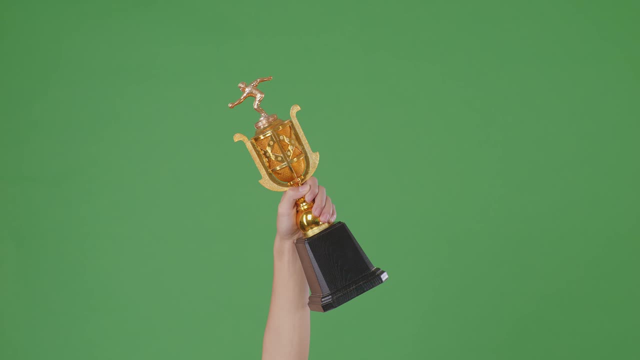hombre sosteniendo un trofeo de oro campeón. fondo de pantalla verde