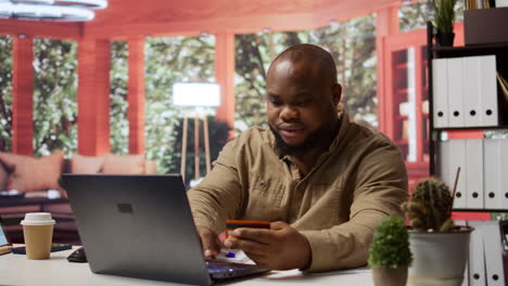 male freelancer using a card to make an online shopping payment