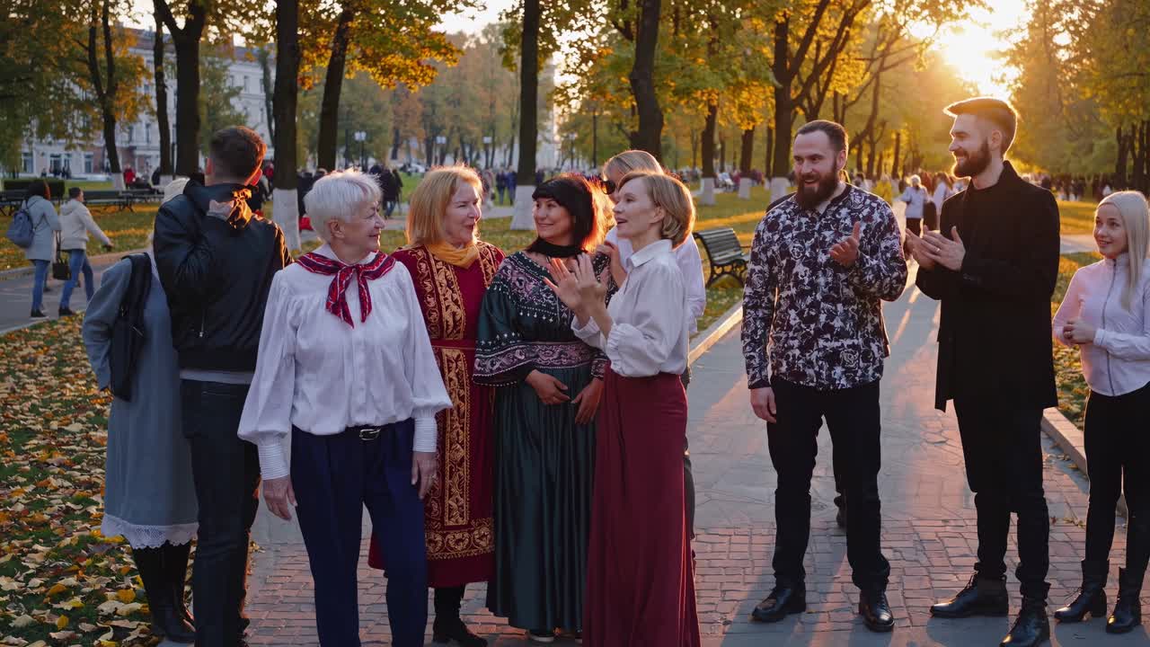A group of people socializing in a park during sunset, captured from a low-angle