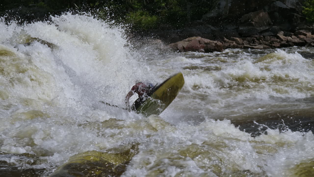 Kayak da sport estremi che si capovolge tra le onde di acque bianche