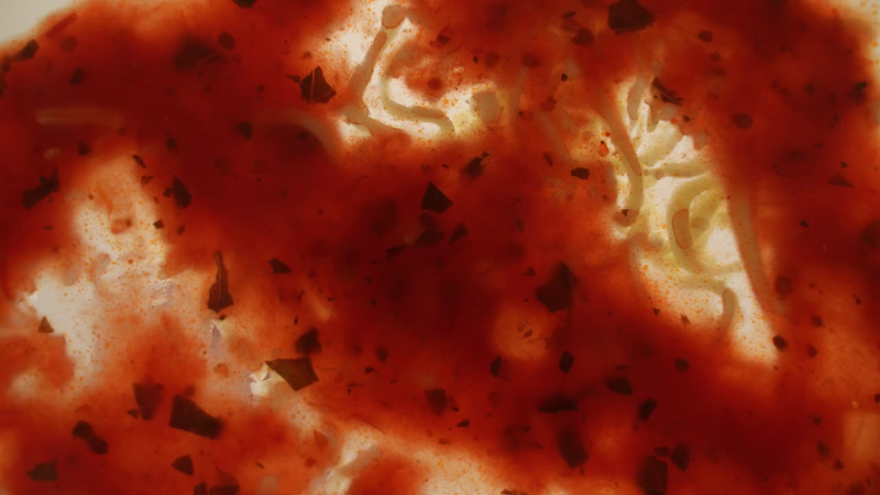 투명한 표면에 토마토 소스에 강판 치즈를 뿌리고 아래에서 봅니다.