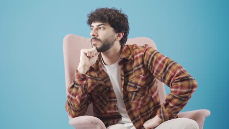 Depressed-looking-young-man-sitting-on-the-sofa-is-in-deep-sad-thoughts.