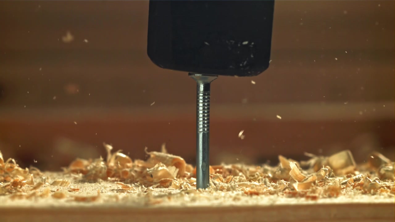 Superzeitlupe eines Nagels, der in Holz eingeschlagen wird