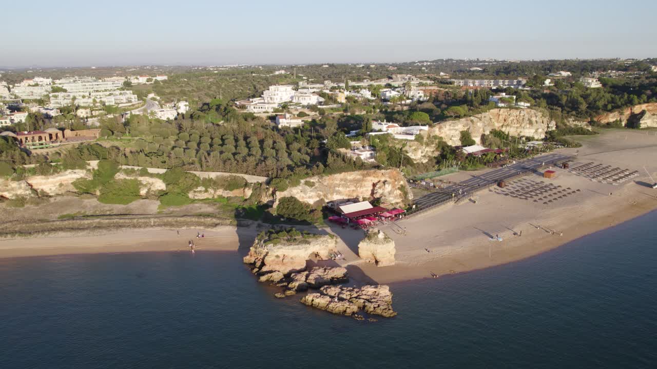 포르투갈의 페라구도 (ferragudo) 에 있는 큰 해변인 프라야 그란데 (praia grande) 의 풍경적인 해가 뜨는 공중 도