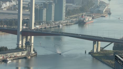 bridge over river with boats and cars