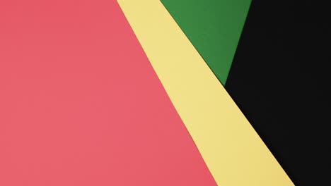 Video-of-red,-yellow-and-green-papers-with-copy-space-on-black-background