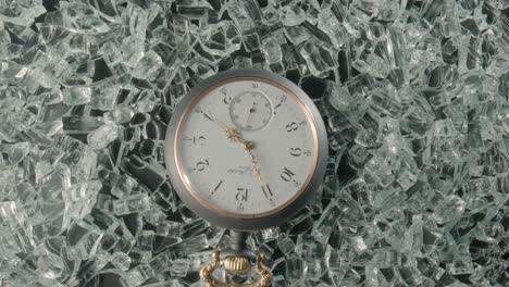 antique pocket watch on broken glass