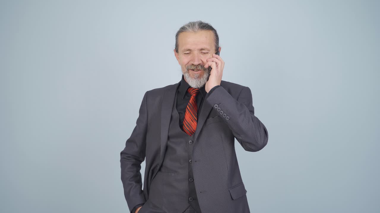 비즈니스맨이 카메라에 행복하게 말하고 있습니다.