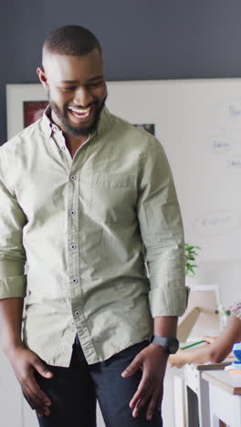 Video of happy african american male teacher during lesson with class of diverse pupils