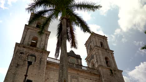 toma de camiones a la derecha con la cámara girando con el sol brillando y mostrando las torres de la catedral de san gervasio en valladolid, yucatán, méxico