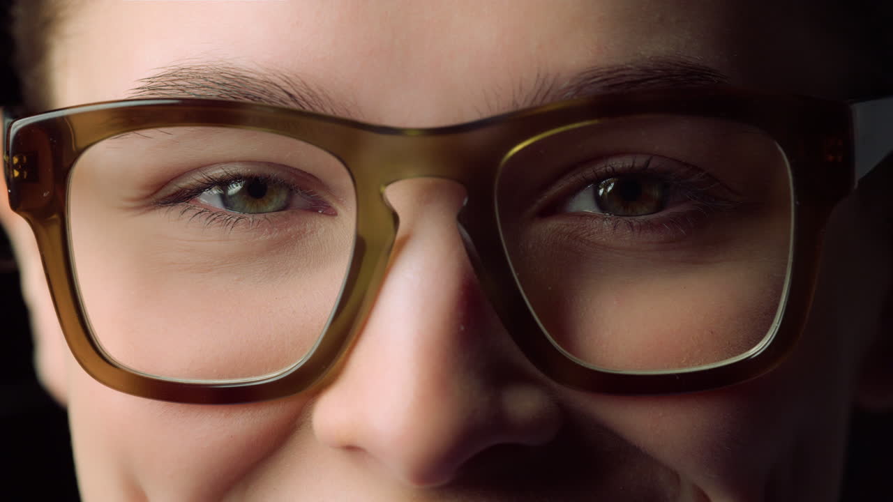 macro de una mujer joven sonriente que usa gafas en el interior. mujer de negocios.
