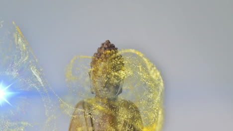 swirling golden particles and blue light surrounding buddha statue in animation