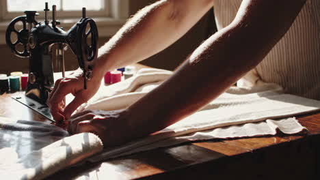 person sewing on an antique sewing machine