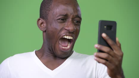 young angry african man shouting at phone