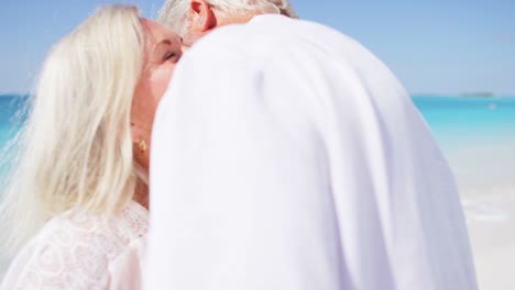 senior caucasian couple dancing together on caribbean beach
