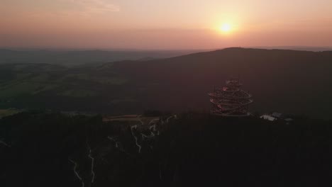 sunset over mountain with wooden observation tower