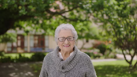 portrait-of-retired-elderly-woman-in-retirement-home-garden-smiling-happy-relaxed