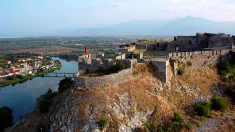 Aerial-of-Rozafa-Castle-with-city-of-Shkoder,-Albania,-in-the-background