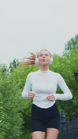 a fit young woman running in nature - capturing the energy of jogging and the joy of listening to music while embracing a healthy lifestyle outdoors