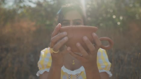 Dreamy-slow-motion-zoom-out-of-a-young-beautiful-Indian-woman-bringing-together-a-broken-piece-of-a-red-clay-pot