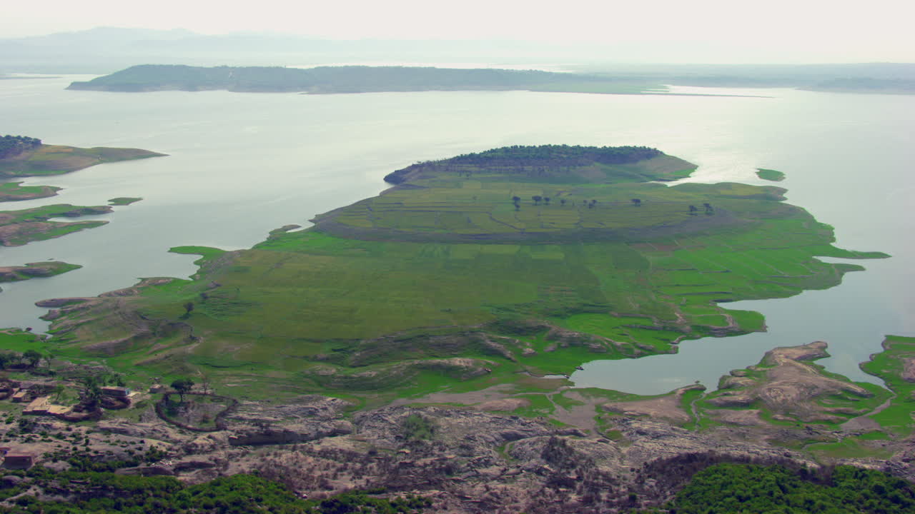 hermosa vista aérea de una irlanda con sol sobre el agua, hierba verde en la tierra, casas antiguas y árboles