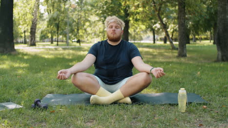 overweight man meditating in park