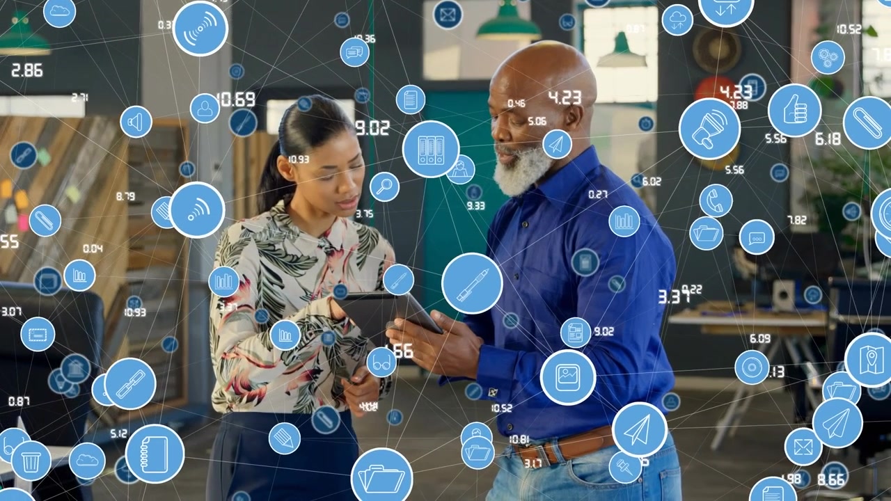 Animation of network of icons over african american man and woman using digital tablet at office