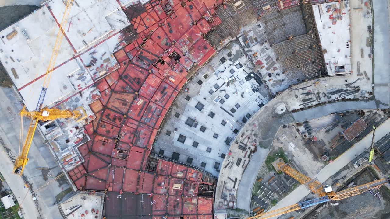 aérea de arriba hacia abajo del sitio de construcción con grúa amarilla y material de construcción