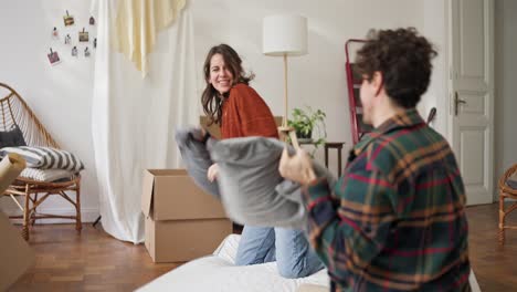 couple having a playful pillow fight in their new home
