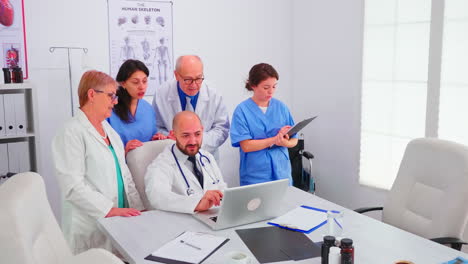 Concentrated-medical-team-using-laptop-together-in-the-hospital-office