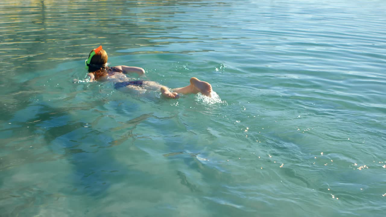 mujer nadando en el agua en la playa 4k