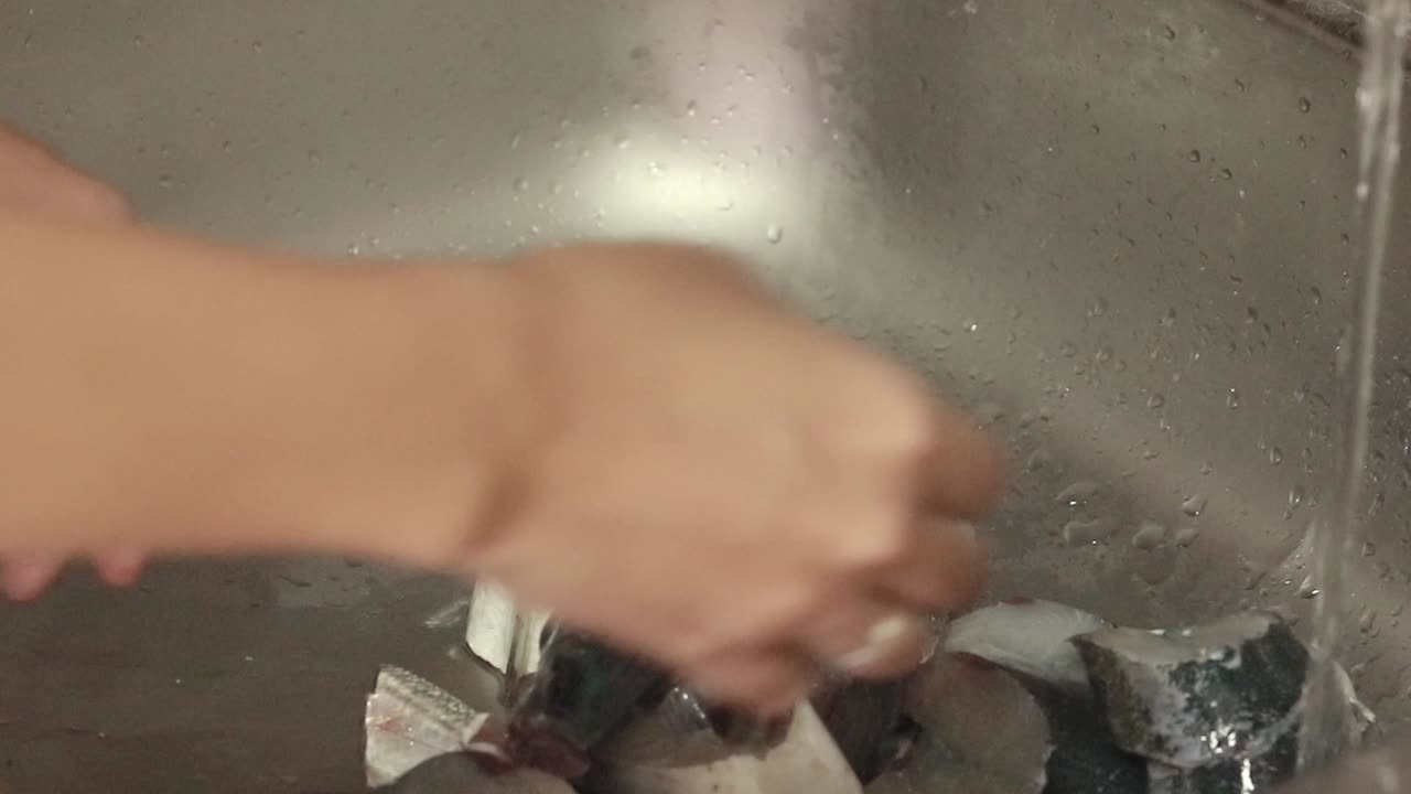 시장에서 새로 구입한 신선한 개진 물고기를 부 싱크대에서 고, 집에서 솔직한 일상 생활의 순간을 보여줍니다.