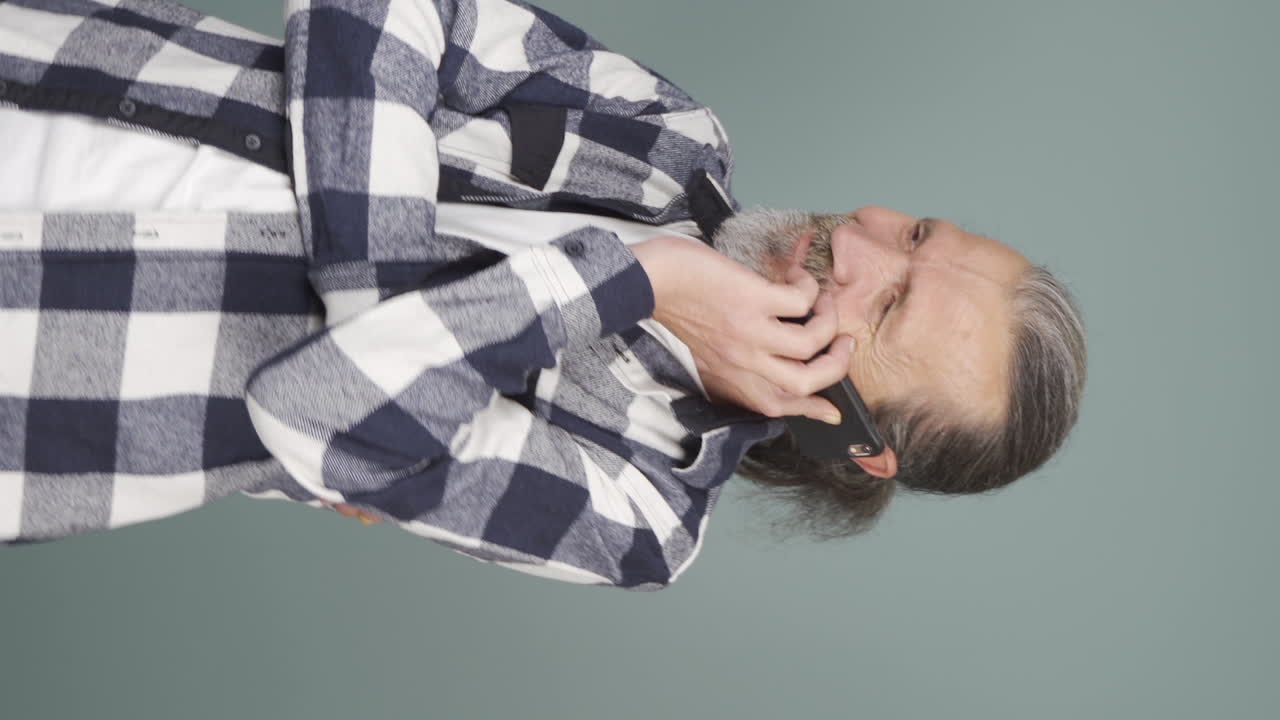 vídeo vertical de un anciano feliz hablando por teléfono.